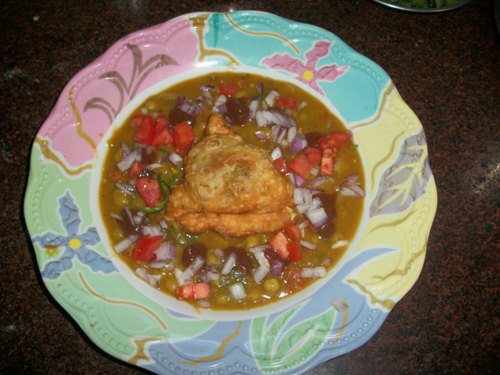 top with onions, tomatoes over samosa